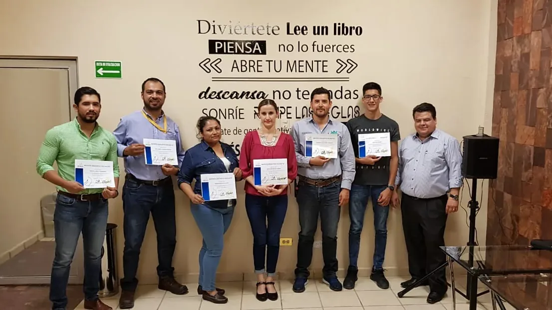 Grupo de egresados de Escala University sosteniendo su constancia de estudios