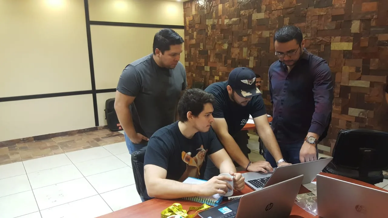Tres profesionales analizando datos en laptops durante una sesion de Escala University