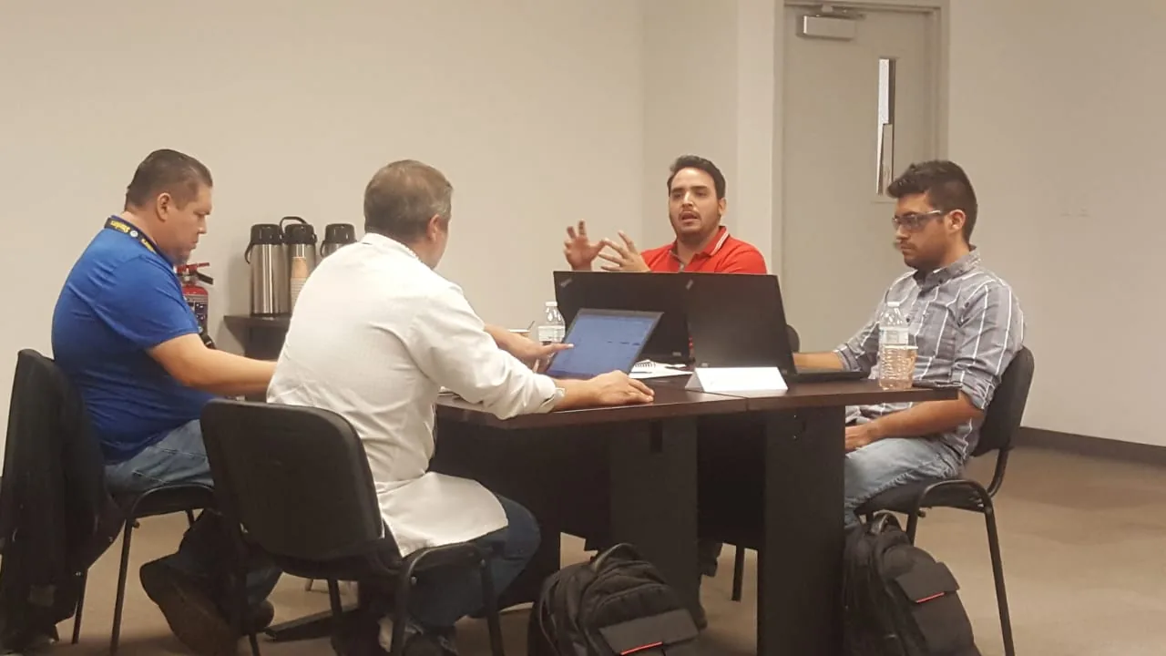 Pequeno grupo trabajando en mesa de reuniones en Escala University
