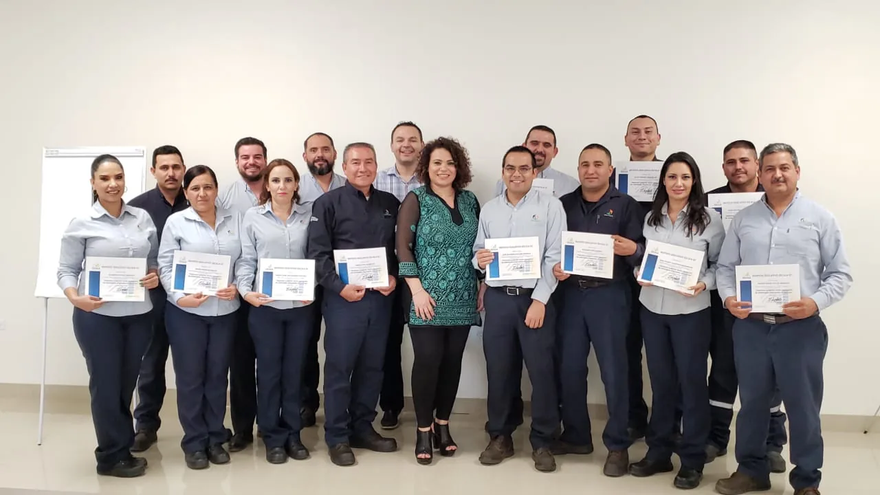 Grupo de trabajadores de planta con sus certificados de Escala University