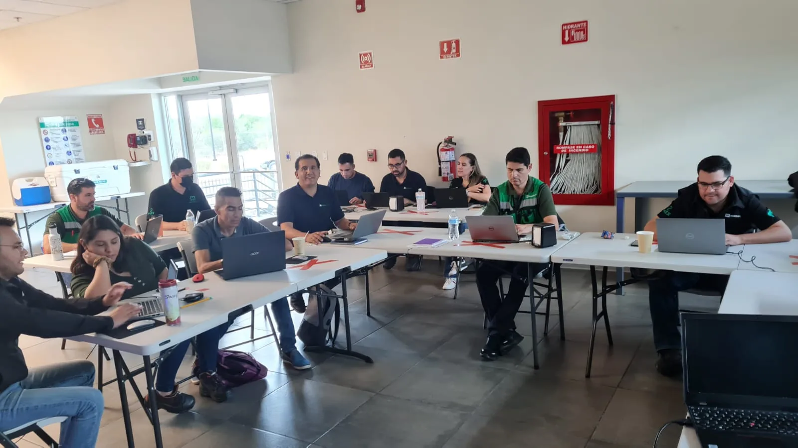 Grupo de profesionales en sesión de capacitación de Escala University en planta industrial