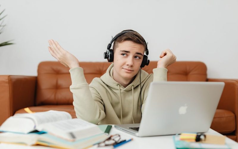 Estudiante con audífonos tomando clase en su laptop