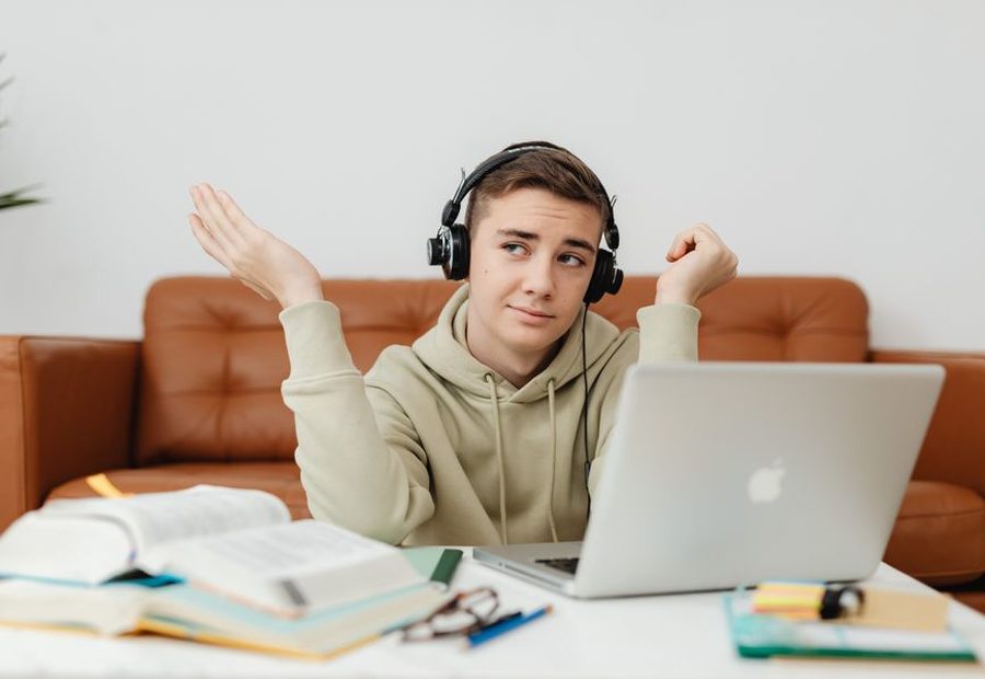 Estudiante con audífonos tomando clase en su laptop